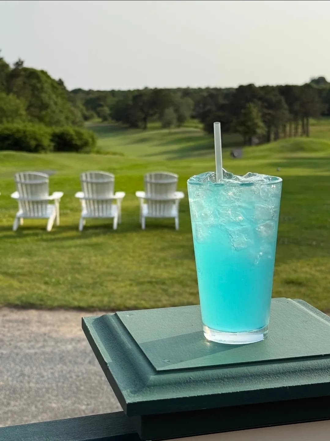 Blue cocktail on the patio with Adirondack chairs